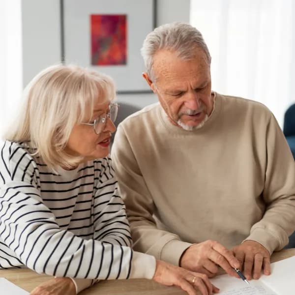 Casal de idosos aposentados analisando contas